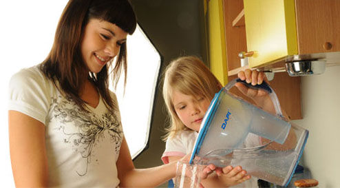 Kobieta i dziecko filtrują razem wodę w dzbanku Dafi